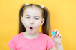 speech therapy. Toddler girl holding the letter O in her hands. Classes with a speech therapist. Girl on isolated yellow