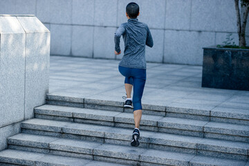 Poster - Fitness woman running up stairs in city