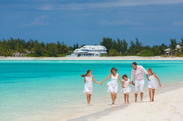 Wall Mural - Happy Caucasian family white clothes walking tropical beach