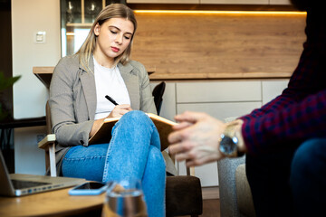 Young man talking to female psychologist during session.