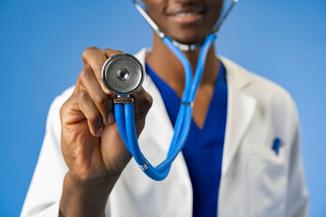 Wall Mural - Cropped photo of black medical doctor with stethoscope on blue