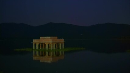 Fototapete - Jal Mahal Water Palace illuminated at night in Jaipur. Rajasthan, India. Horizontal pan