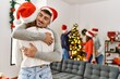 © Krakenimages.com - Group of young people on christmas meeting. Couple smiling happy standing and hugging at home.
