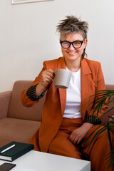 fashion business woman queer portrait, sitting on couch at modern workplace