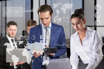 Poster - Attractive european businesspeople in blurry modern office interior using laptops and tablets with abstract digital business chart and map hologram. Company, teamwork and digital data concept. 