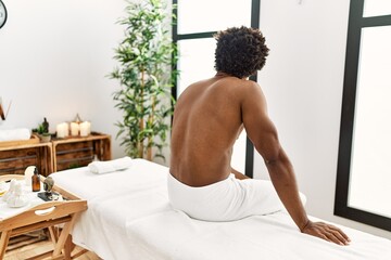 Poster - Young african american man sitting on massage board at beauty center