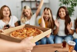Fototapeta Zachód słońca - Group of young friends woman surprise for italian pizza sitting on the sofa at home.