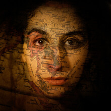 A Woman With A World Map Projected Over Her Face