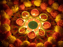 Diwali Rangoli With Lit Diyas And Marigold Flowers