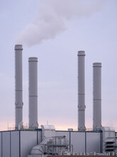 Factory With Industrial Chimneys At Sunset