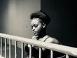 © Scopio - Grayscale portrait of young African lady beside railing