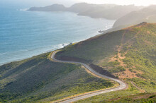 Winding Road Along The Coast Of California Partially Covered With Fog Rolling In From The Ocean At Sunset