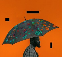 Man In Gray Shirt Holding An Umbrella Against Orange Background