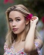 © Scopio - Portrait of young Blonde woman with blue eyes with flower on her head