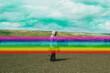 © Scopio - Side view of young man in pink hoodie standing on plateau outdoor with graphic strip of rainbow