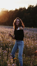 Teenage Girl In Tank Top And Blue Denim Jeans Standing On Flower Field