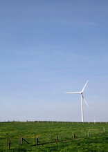 Wind Turbine On Green Grass Field Under Blue Sky