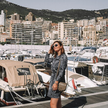 Woman In Dress With Sunglasses Standing Beside Docked Boats