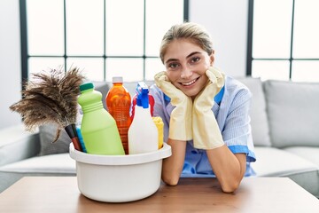 Wall Mural - Young caucasian woman smiling confident wearing cleaner uniform at home