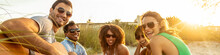 Panoramic Group Portrait Of Friends Relaxing On Beach