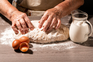 Hands of granny kneads dough. 80 years old woman hands kneading dough. homemade baking. Pastry and cookery