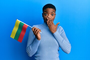 Sticker - Young african american woman holding lithuania flag covering mouth with hand, shocked and afraid for mistake. surprised expression