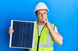 © Krakenimages.com - Handsome young man holding photovoltaic solar panel serious face thinking about question with hand on chin, thoughtful about confusing idea