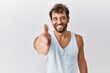 © Krakenimages.com - Young handsome man standing over isolated background smiling friendly offering handshake as greeting and welcoming. successful business.