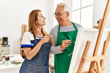 Poster - Middle age paint teacher and student smiling happy painting at art studio.