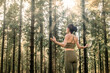 © Rob Wilkinson - woman standing in a forest at sunrise, practicing yoga and meditating wearing sportswear.