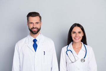 Wall Mural - Photo of two positive friendly doctors therapist diagnosis look camera isolated on grey color background