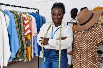 Sticker - Young african american woman shopkeeper standing with arms crossed gesture at clothing store