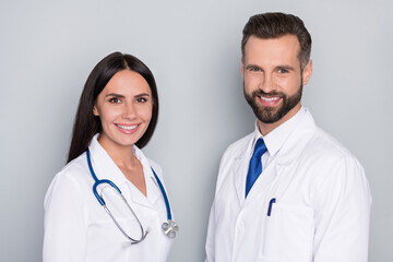 Canvas Print - Profile photo of two friendly smart doctors toothy smile look camera isolated on grey color background