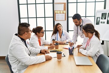 Wall Mural - Group of hispanic doctor discussing in a medical meeting at the clinic office.