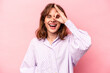 © Asier - Young caucasian woman isolated on pink background excited keeping ok gesture on eye.