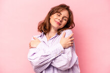 Young Caucasian Woman Isolated On Pink Background Hugs, Smiling Carefree And Happy.