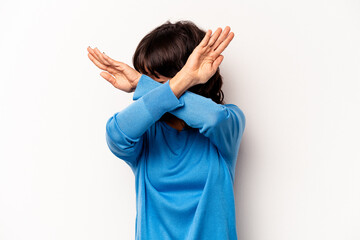 Young hispanic woman isolated on white background keeping two arms crossed, denial concept.