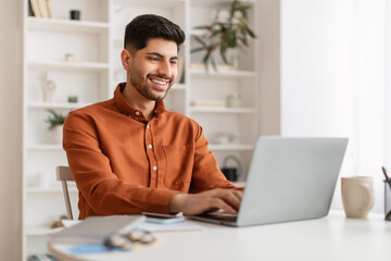 Poster - Arab man using laptop sitting at desk in office