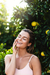 Poster - Portrait of beautiful woman with smooth skin against lemon trees