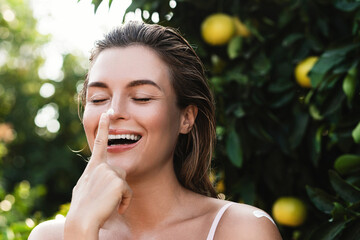 Wall Mural - portrait of beautiful woman with moisturizing cream on her nose