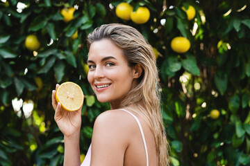 Wall Mural - beautiful woman with smooth skin with a lemon fruit in her hands