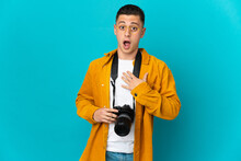 Young  Caucasian Photographer Man Isolated On Blue Background Surprised And Shocked While Looking Right