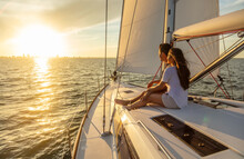 Hispanic Couple Relaxing On Private Yacht At Sunrise