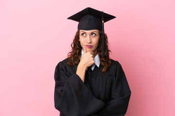 Canvas Print - Young university graduate woman isolated on pink background having doubts and with confuse face expression