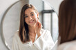 © Prostock-studio - Closeup Of Beautiful Young Lady Cleansing Skin With Cotton Pad Near Mirror