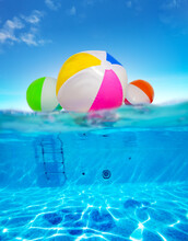 Inflatable Balls Float In Water, Split Underwater Pool Image