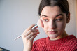 © puhimec - Portrait of a young woman, the process of doing makeup with brushes.