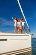 © Spotmatik - Hispanic family waving from bow of private yacht