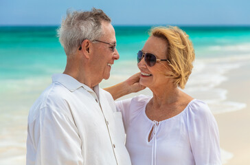 Affectionate senior couple smiling by the ocean Bahamas