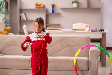 young little girl doing sport exercises at home